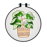 Embroidery hoop with a potted plant design on a white background