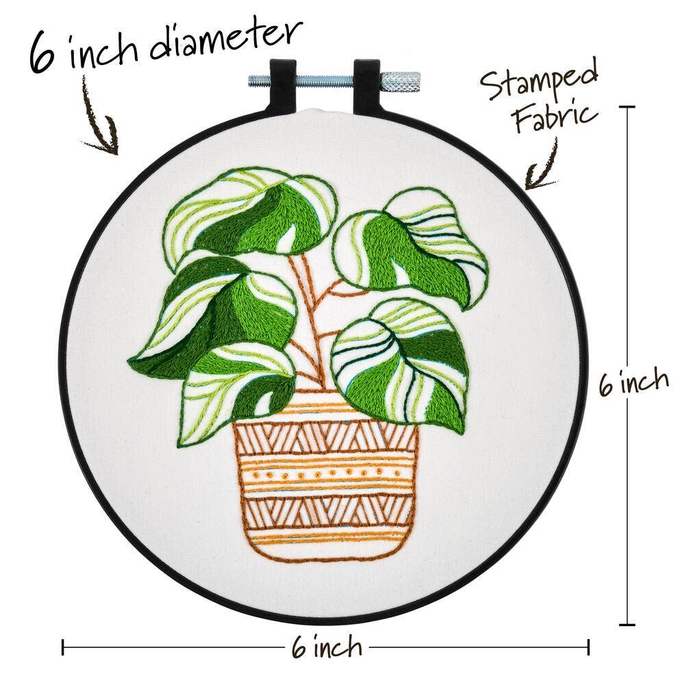 Embroidery hoop with a plant design, labeled for size and material.
