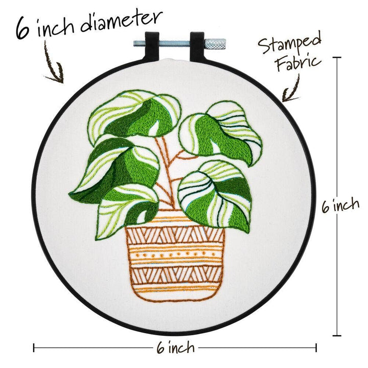 Embroidery hoop with a plant design, labeled for size and material.