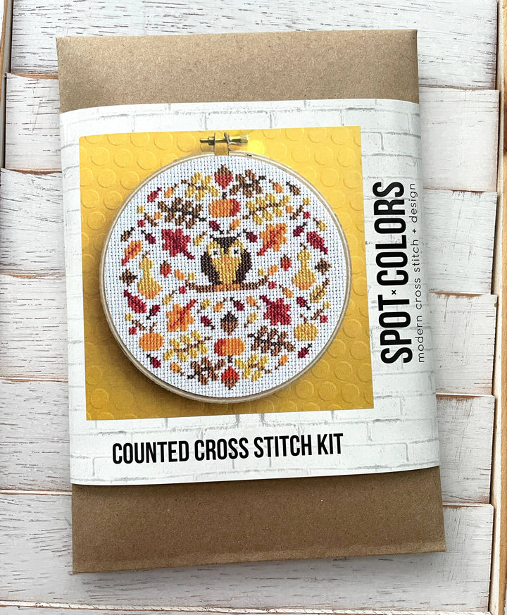 Counted cross stitch kit with owl design on a wooden surface
