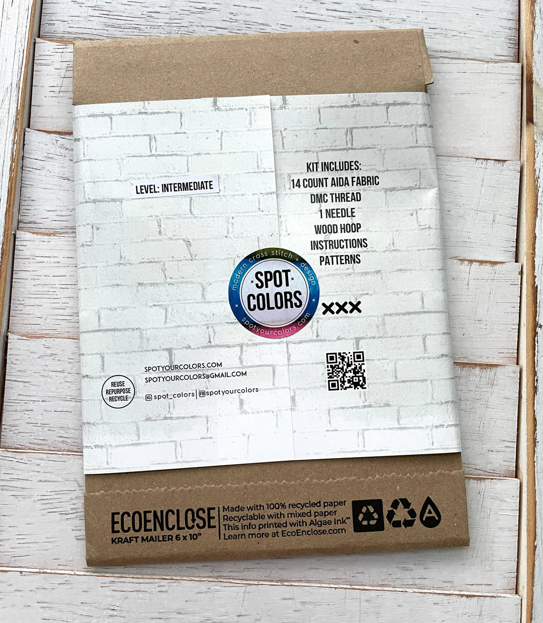 Eco-friendly craft kit packaging with Spot Colors branding on a wooden surface