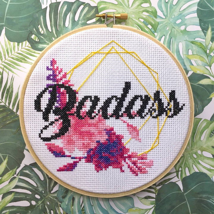 Embroidery hoop with 'Badass' and floral design on a leafy background