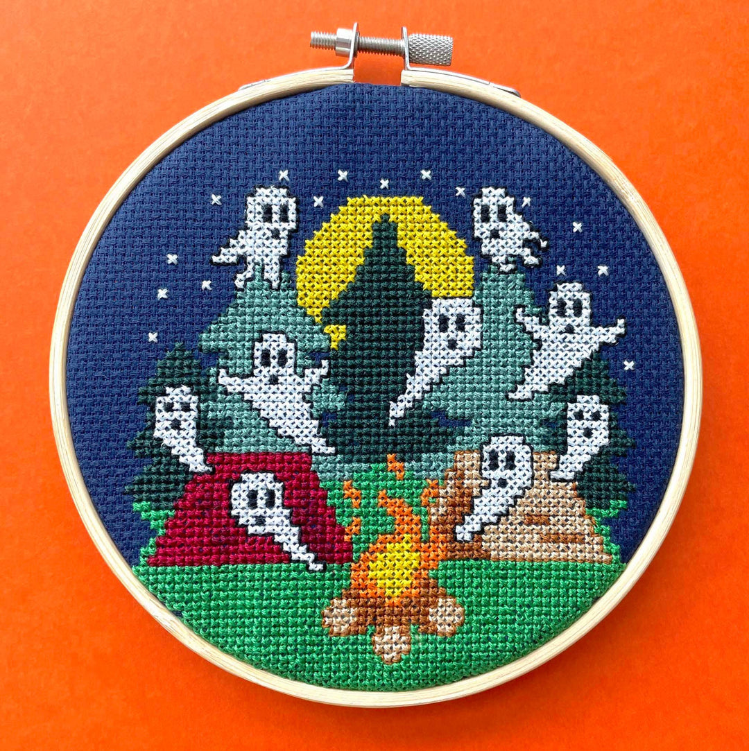 Embroidery hoop with ghost-themed cross-stitch design on an orange background