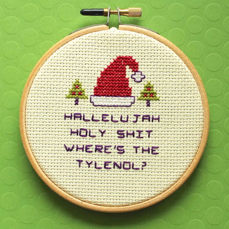Embroidery hoop with cross-stitched design on a green background