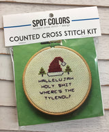 Cross stitch kit with a humorous design on a green background