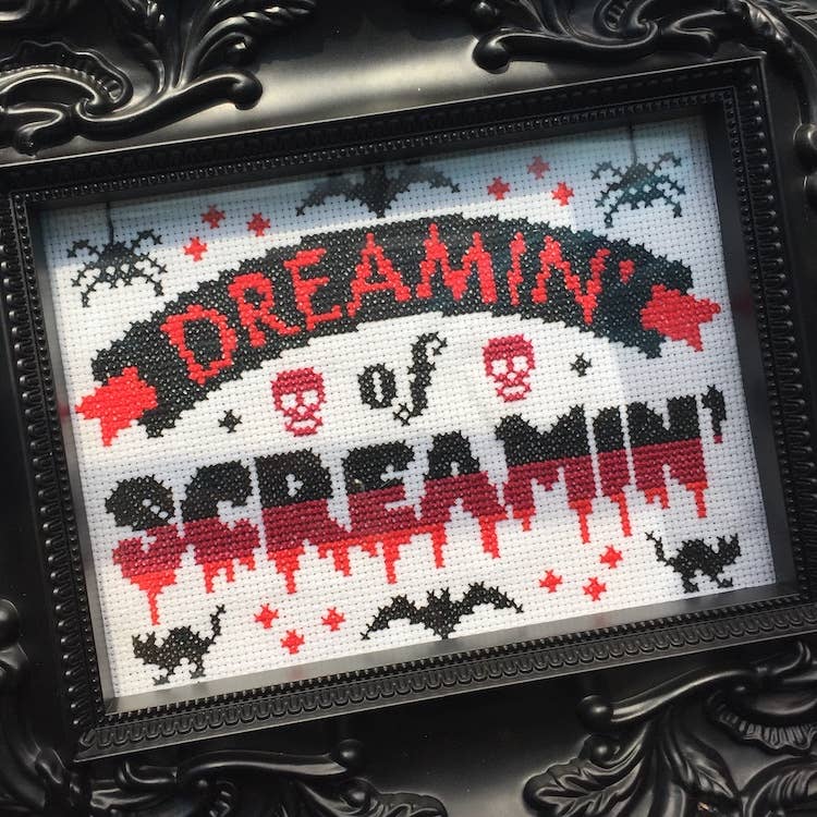 Framed cross-stitched artwork with 'Dreamin' of Screamin'' text and Halloween-themed designs.