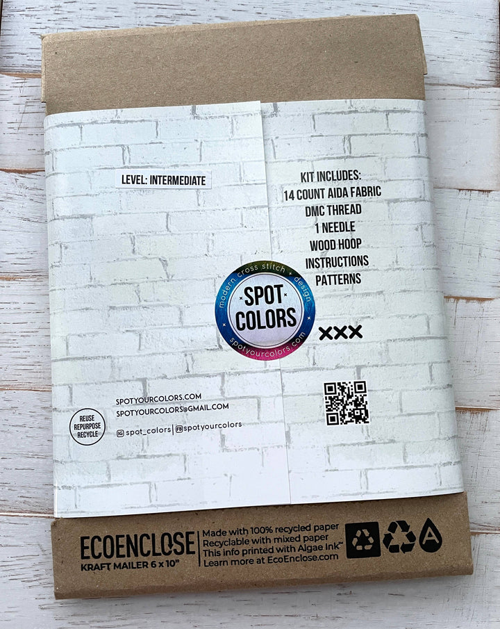 Packaging of Spot Colors embroidery kit with eco-friendly label on a wooden surface