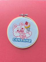 Cross-stitched design of a cartoon pig with a bow tie in an embroidery hoop on a pink background.