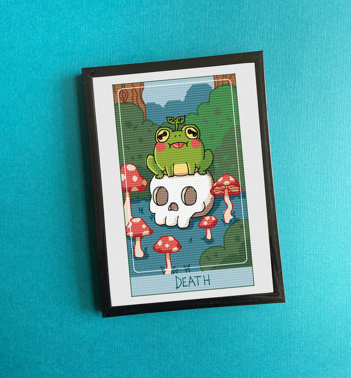Framed artwork with a cartoon frog on a skull surrounded by mushrooms against a blue background