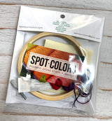 Embroidery kit with hoop, threads, and tools in clear packaging on a wooden surface.